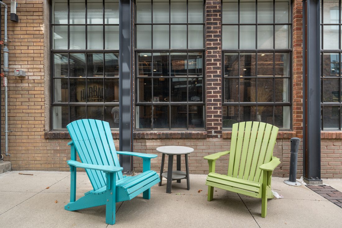 The glass-roofed courtyard at Harbach Lofts, with chairs set between the two brick buildings