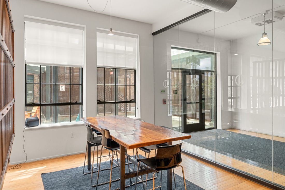 A shared work table by the factory windows in a Harbach Lofts common area
